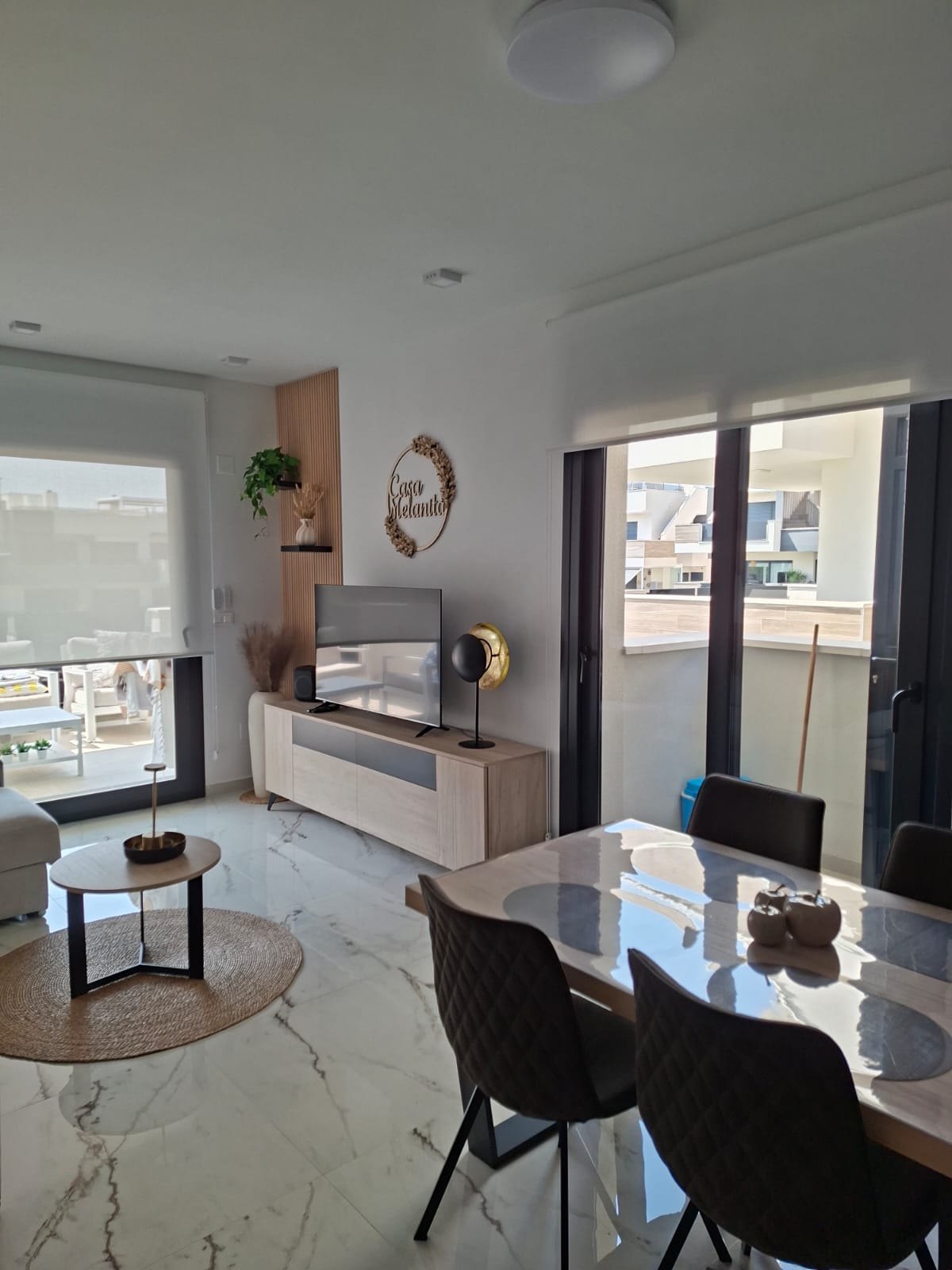 Woonkamer met flatscreen en zicht op het terras